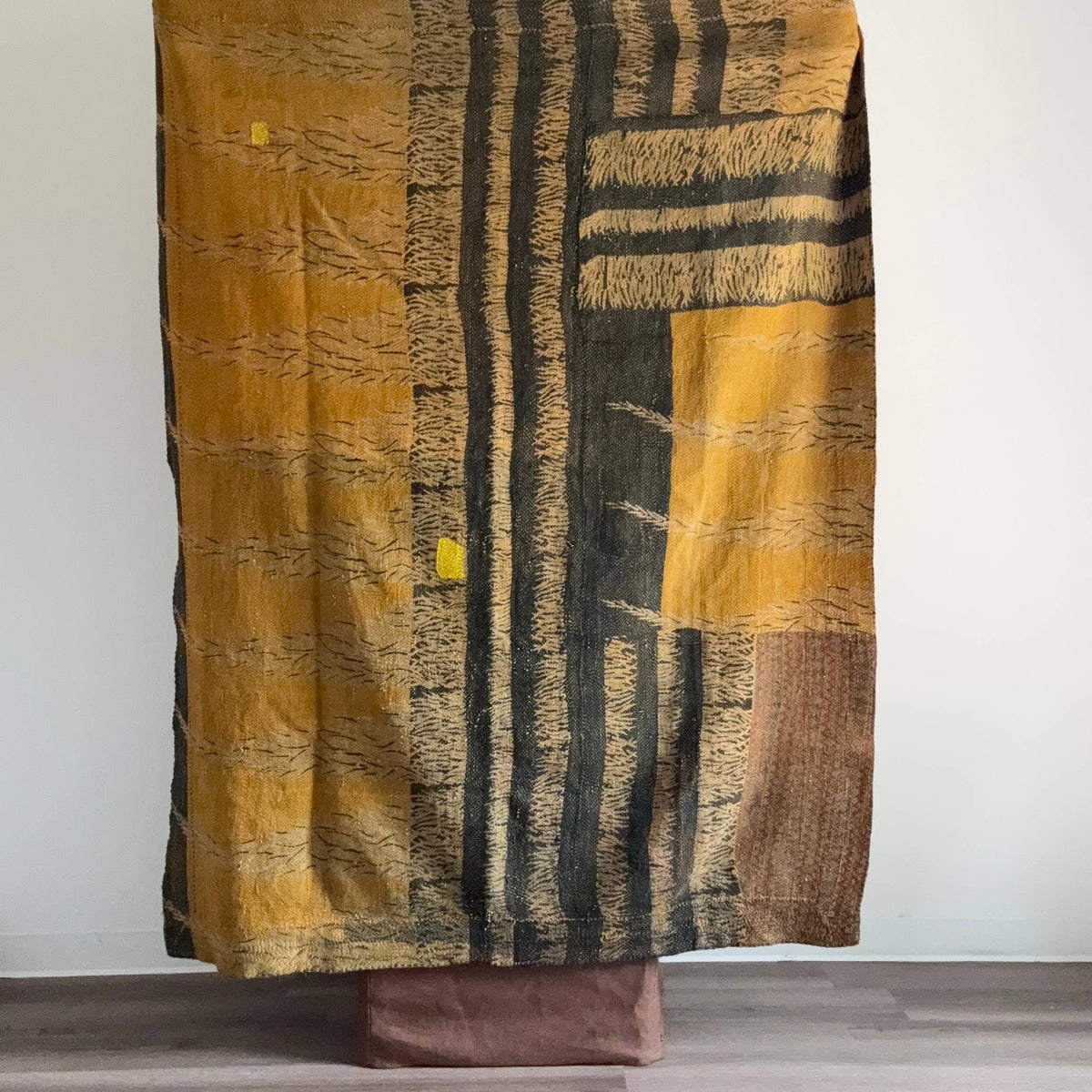 Textured fabric with brown, black, and gold patterns draped over a surface.