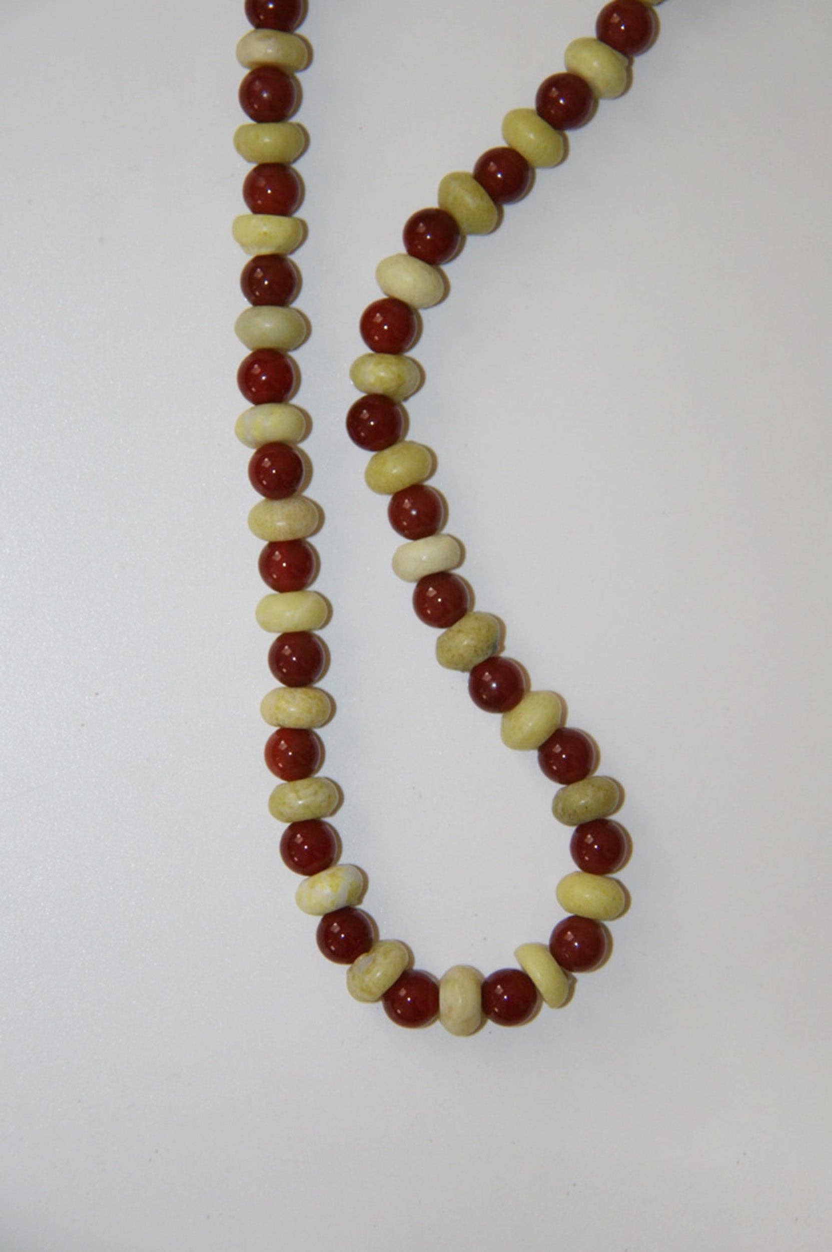 Necklace with red and beige beads on a white background