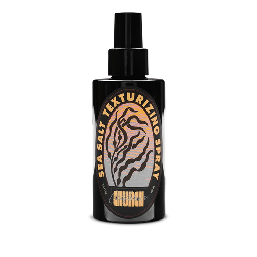 A black spray bottle of Church California Sea Salt Texturizing Spray with a black nozzle, featuring a circular label with a tiger-stripe design and gold lettering on a white background.