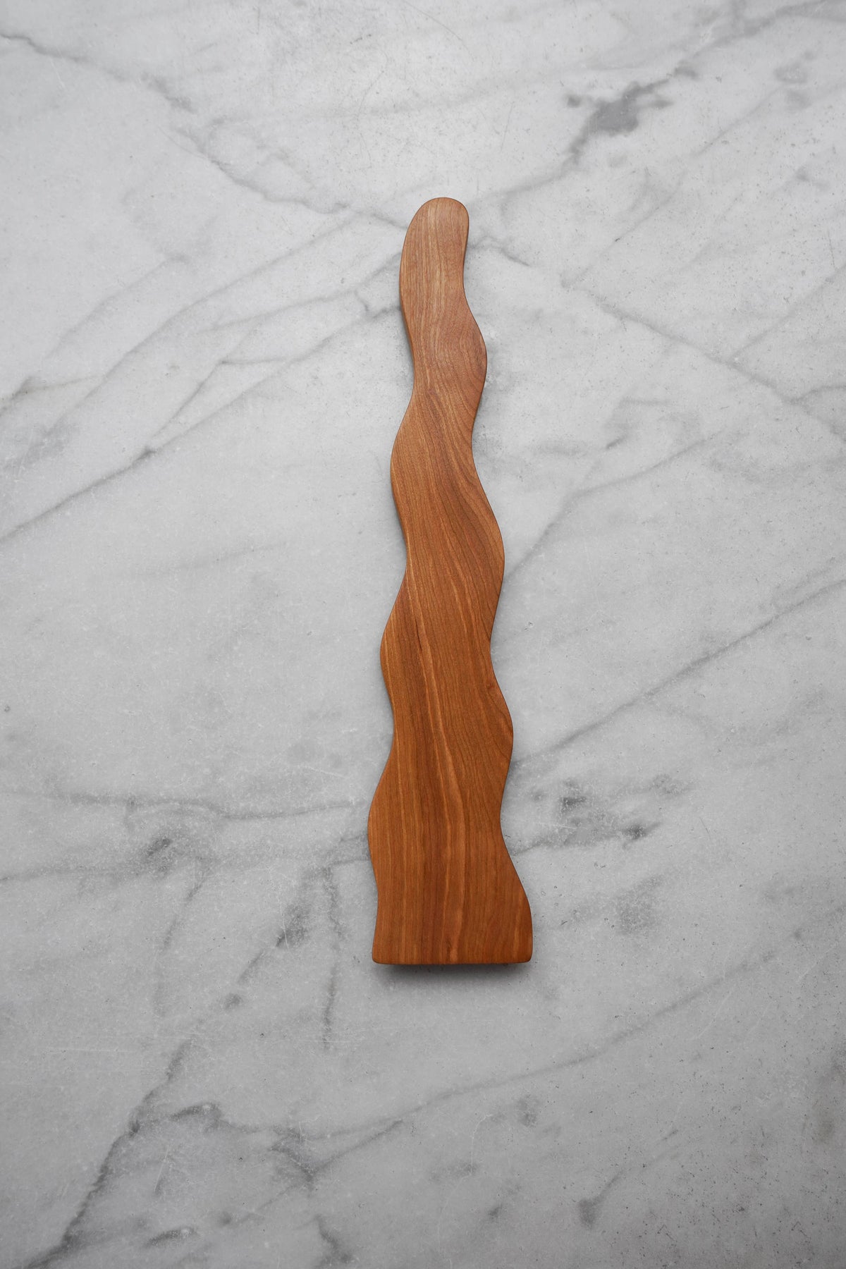 Wooden wavy object on a marble surface