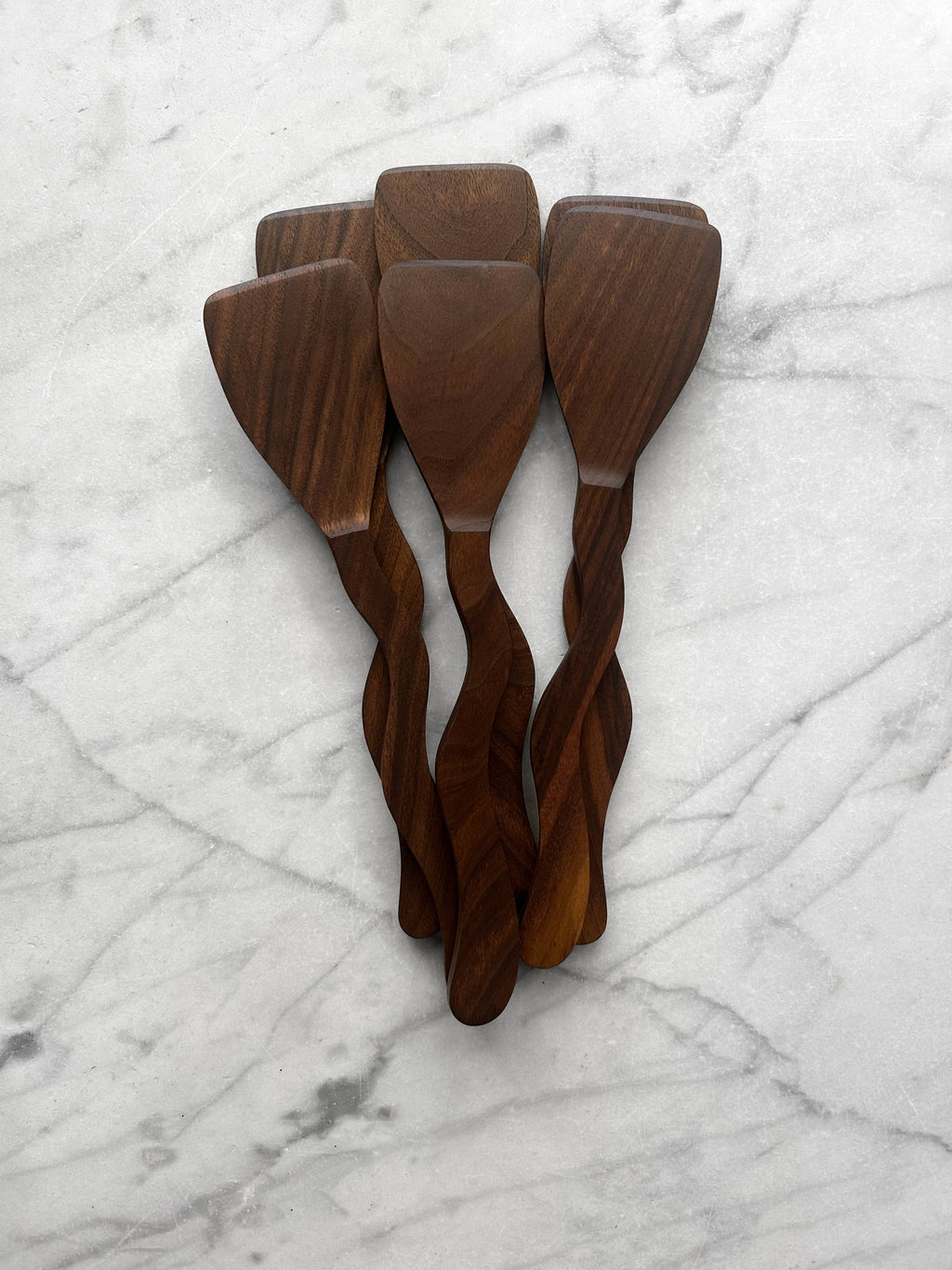 Set of three wooden spatulas on a marble surface