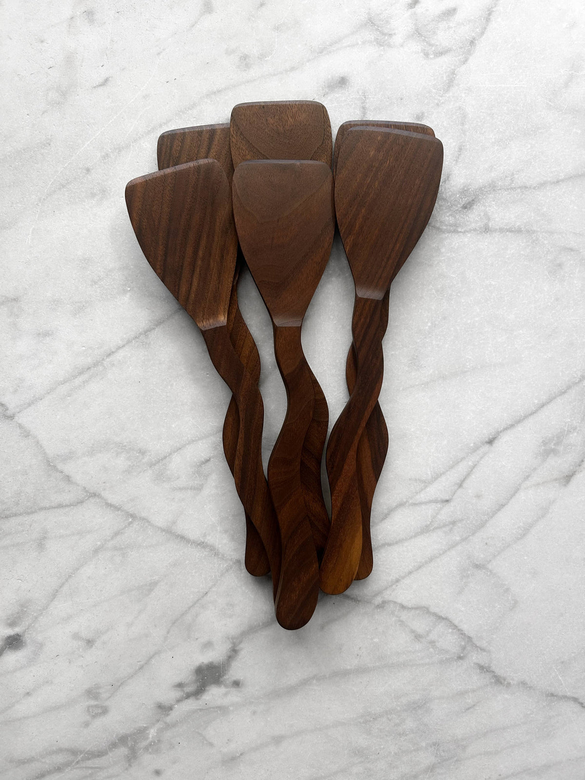 Set of three wooden spatulas on a marble surface