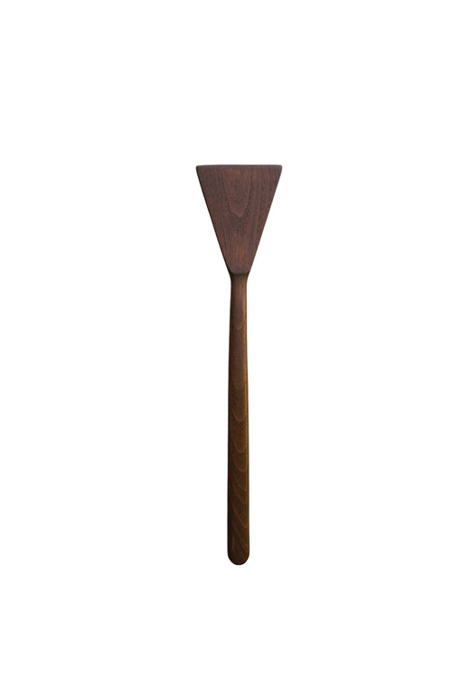 A dark brown wooden spatula with a triangular head and a long handle, placed vertically on a white marble surface with gray veining.