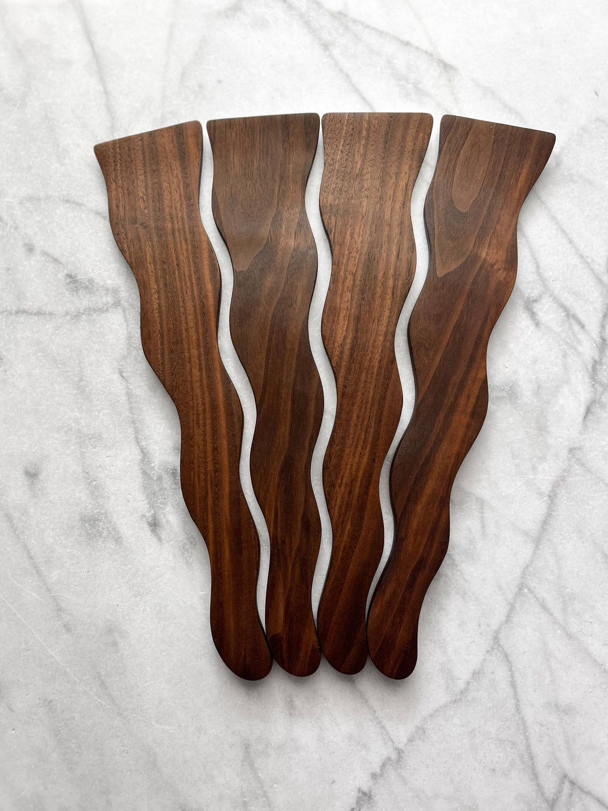 Wooden cutting boards with wavy design on a marble surface