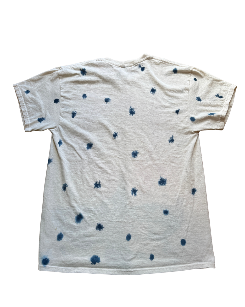 An off-white short-sleeve t-shirt with a blue tie-dye splash pattern, shown flat against a white background.