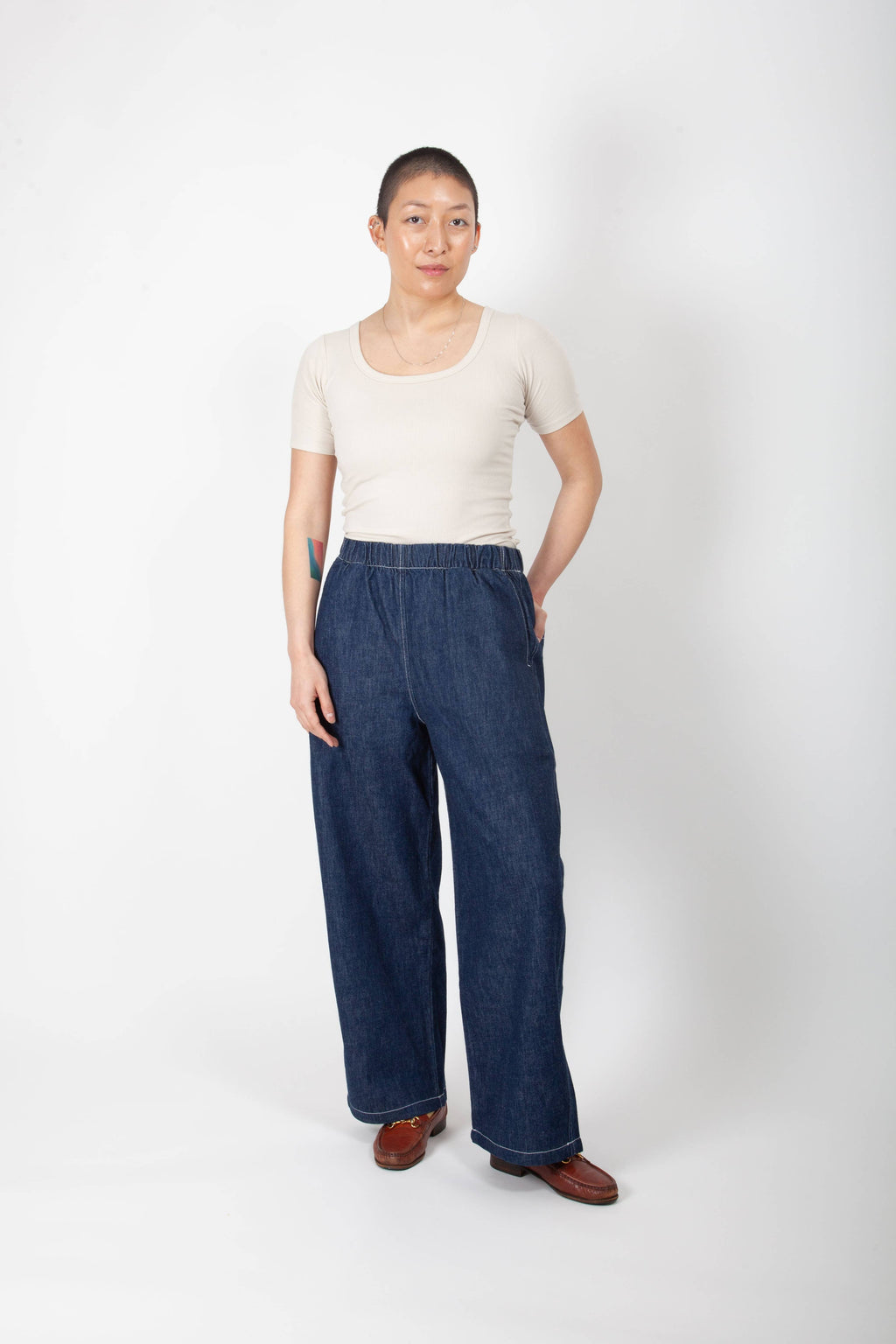 Person wearing a white top and blue jeans on a white background
