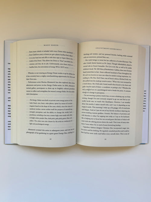 An open book with cream-colored pages and dense black text, photographed from above against a plain light background.