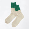 A pair of ribbed ankle socks in cream with a dark green ribbed cuff, displayed on a clean white background.