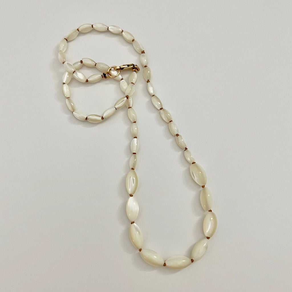 Necklace with shell beads on a light gray background