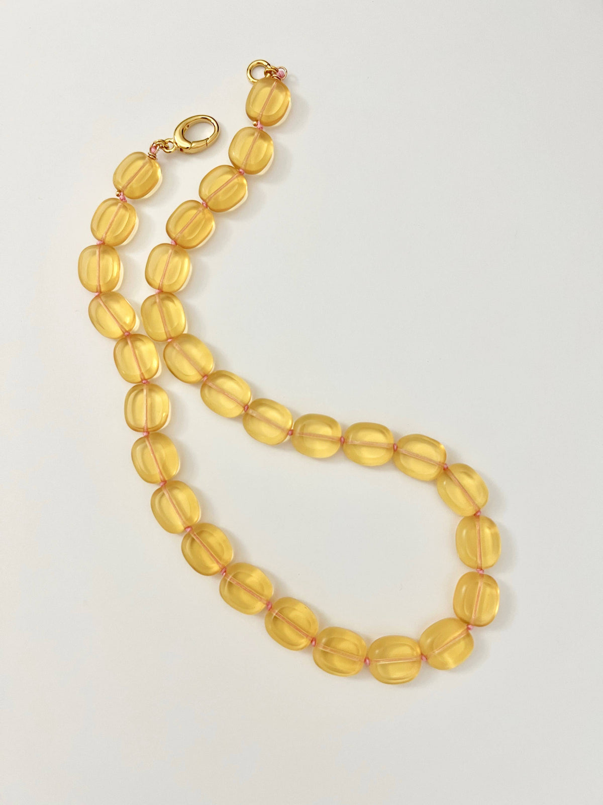 Yellow beaded necklace on a light gray background
