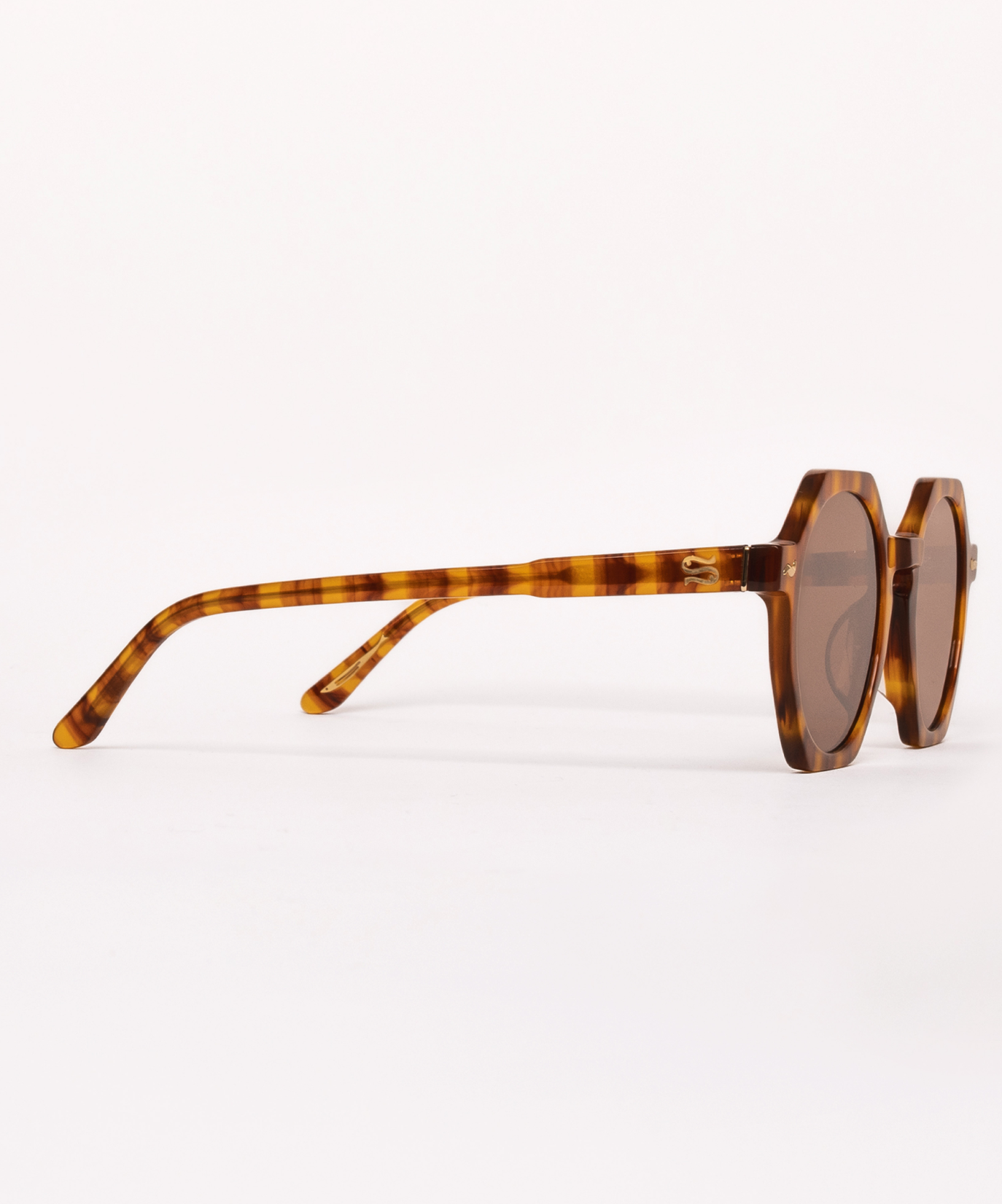 Sunglasses with tortoiseshell frame and dark lenses on a white background