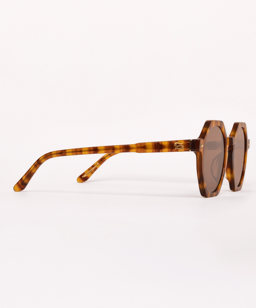 Sunglasses with tortoiseshell frame and dark lenses on a white background