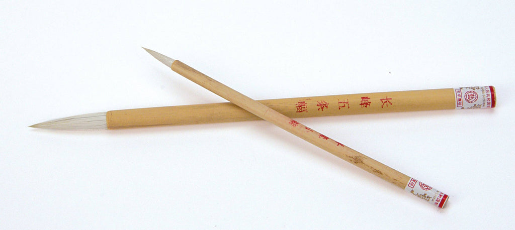 Two wooden brushes with red text on a white background