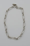 Silver chain necklace on a light gray background